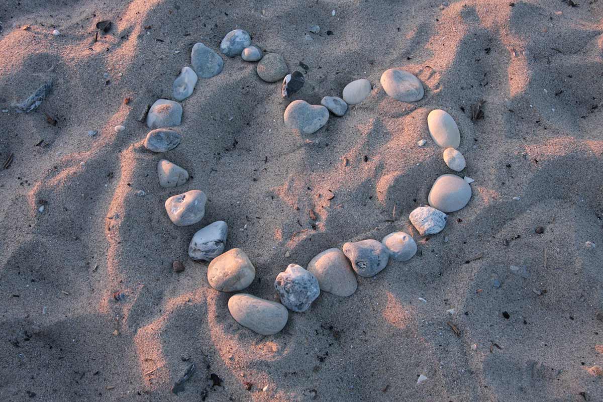 Herz aus Steinen im Sand